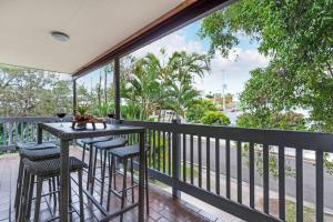 a balcony with a table and chairs and a view of a street at Beach Haven at Alex Heads in Alexandra Headland
