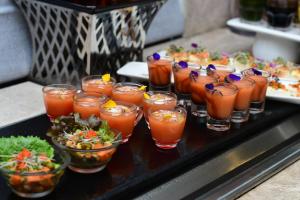 a table topped with glasses of drinks and salads at Soaltee Westend Premier in Nepālganj