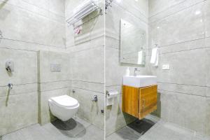 a bathroom with a toilet and a sink and a mirror at FabHotel Prime Royal Maple in Ludhiana