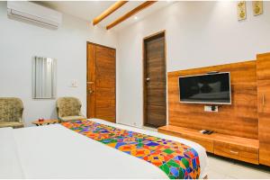 Schlafzimmer mit einem Bett und einem Flachbild-TV in der Unterkunft FabHotel Prime Royal Maple in Ludhiana