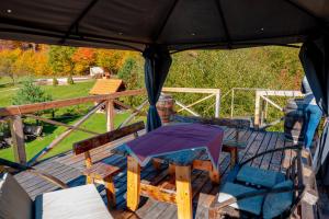 - une terrasse couverte avec une table et des chaises dans l'établissement Forest House, à Zăbala