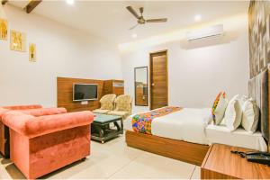 una camera con letto, TV e divano di FabHotel Prime Royal Maple a Ludhiana