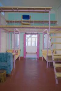マイソールにあるRahee Bi Roambay - Backpacker Hostelの二段ベッドとソファが備わる空の部屋