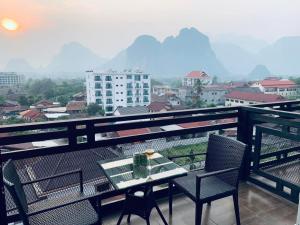 een tafel en stoelen op een balkon met uitzicht bij VANG VIENG TOPVIEW HOTEL in Vang Vieng