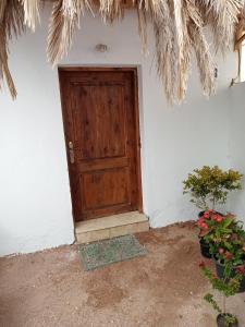 una porta di legno su un muro bianco con piante in vaso di House with backyard in dahab a Dahab