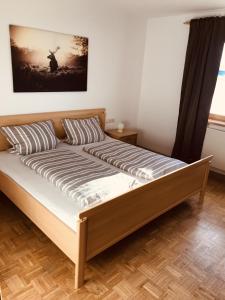 a bed in a bedroom with a picture on the wall at Ferienwohnung Wia Dahoam in Steingädele