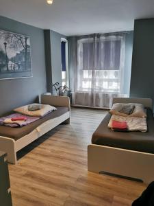 Cette chambre comprend 2 lits et une fenêtre. dans l'établissement Flensburg Strandnah, à Flensbourg