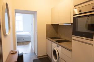 a kitchen with a washer and a sink and a microwave at DS Apartment 5 in Vienna