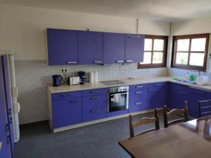una cocina con armarios azules y una mesa. en Ferienwohnung mit 123qm für 8 Personen mit sehr großem Garten, einfache Innen-Ausstattung, en Leipzig