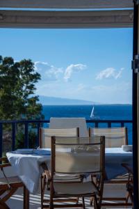 una mesa y sillas en un balcón con vistas al océano en Perdika Sea Soul, en Perdika