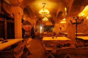 a restaurant with tables and chairs and a chandelier at Penzion Hrad in Frýdek-Místek