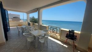 un balcone con tavolo e sedie e l'oceano di 058 Spiaggia di SalentoInVacanza.Com a Torre Pali