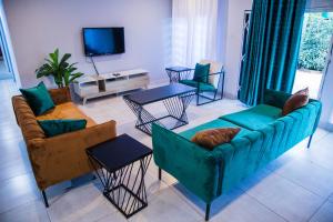 uma sala de estar com sofás e mesas e uma televisão em Blue Agave F2 em Lusaka