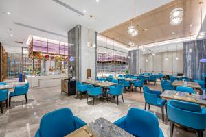 a restaurant with blue chairs and tables at Evwa Platinum Hotel in Huizhou
