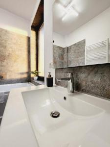 uma casa de banho com um grande lavatório branco num quarto em Armina's Residence em Uisenteş