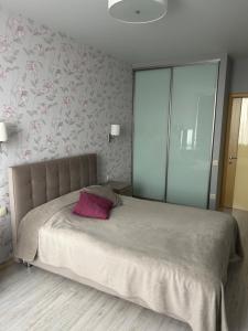 um quarto com uma cama grande e uma almofada rosa em Нова затишна квартира Студіо плюс спальня біля метро Житомирська em Kiev