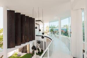 a staircase in a house with white walls and windows at Villa Rose in Seminyak