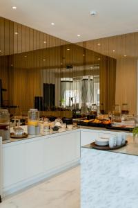 cocina grande con encimeras blancas y paredes de madera en Nava Motel & Storage en Wiener Neustadt