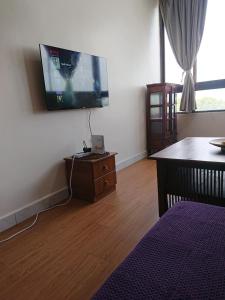 a living room with a flat screen tv on the wall at Butterworth Seaside view Family spacious in Butterworth