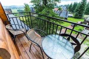 a table and chairs on a balcony with a view at Turbacz- Apartament na Leśnej 10 in Bukowina Tatrzańska