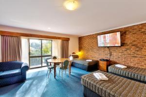 um quarto de hotel com uma mesa e uma parede de tijolos em Hume Country Motor Inn em Albury