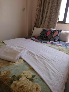 a bed with a white blanket and a window at Butterworth Seaside view Family spacious in Butterworth