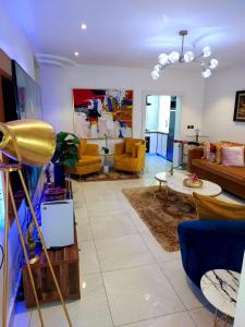 a living room with yellow chairs and a couch at HOMEDALES Freedom Way LEKKI Phase1 LAGOS in Lekki