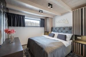 a bedroom with a large bed and a table at Chalet Pod Brdom - Apartments in Ružomberok