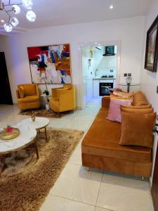 a living room with a couch and a table at Professionals Friendly with Work Station PS5 & near Beaches in Lekki