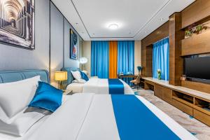 a hotel room with two beds and a flat screen tv at QingMan Apartment Guangzhou Zhujiang New Town East Railway Station Branch in Guangzhou