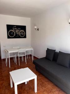 a living room with a couch and tables and a bike painting at Tantul Crissol 211 Apto 1Hab in Los Cristianos