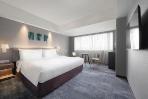 台北的住宿－ILLUME 茹曦酒店，酒店客房设有一张大床和一张桌子。