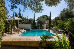 Una piscina en un patio con una sombrilla. en Finca Es Carregador, en Capdepera