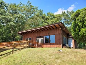 a small house with a large deck on a hill at Its Owl Good in Luray