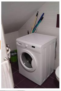 a washing machine in a bathroom with two baseball bats at Apartamento de 2 habitaciones. in Dor