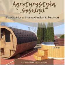 a book about a wooden house with a building at Agroturystyka nad Biebrza Sośniaki in Goniadz