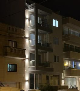 a tall apartment building at night with lights at Skylark 2 Apartment with Terrace in Is-Swieqi