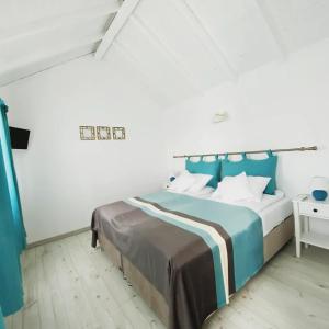 a bedroom with a bed with a blue headboard at Breeze By The Lake - Cazare cu jacuzzi pe malul lacului 