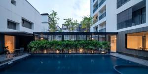 曼谷的住宿－Lilit Bang Lumphu Hotel，一座建筑物中央的游泳池