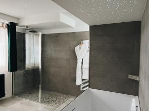 uma casa de banho com um chuveiro e uma banheira com uma banheira. em Domaine Labouroume em Salies-de-Béarn