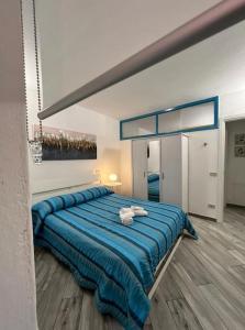 - une chambre avec un grand lit et une couverture bleue dans l'établissement I SASSI BLU, à Riomaggiore