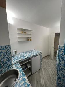 La salle de bains est pourvue d'un lavabo et de carrelage bleu et blanc. dans l'établissement I SASSI BLU, à Riomaggiore
