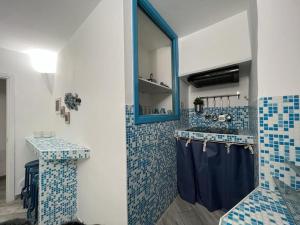 a bathroom with blue tiled walls and a mirror at I SASSI BLU in Riomaggiore