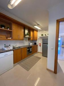 a large kitchen with wooden cabinets and appliances at Sam's House in Foz do Arelho