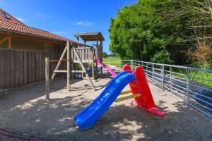 a playground with a plastic slide and a slideintend at Ferienwohnung Mühlenblick auf dem Ferienhof Eschen in Moorweg