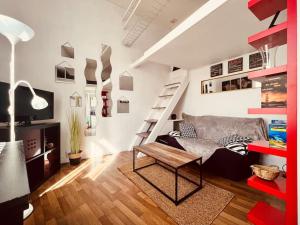 a living room with a couch and a stair case at Le Jean -Jaures 2 / Charmant P1 bis in Nîmes