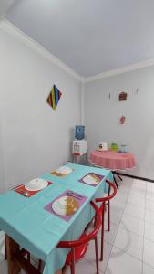 una mesa azul con dos sillas y una cometa en la pared en Dafaira holidayhome batu, en Tlekung