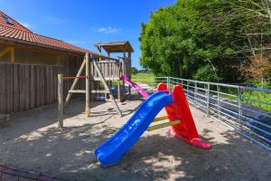 a playground with a plastic slide and a slideintend at Ferienwohnung Waldblick auf dem Ferienhof Eschen in Moorweg