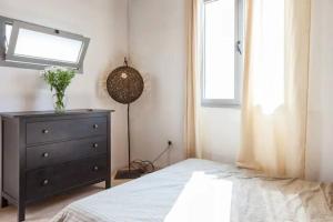um quarto com uma cama, uma cômoda e uma janela em BIG BIG TERRACE KEREM COSY STUDIO em Tel Aviv