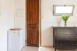 um quarto com uma porta, uma cômoda e uma geladeira em BIG BIG TERRACE KEREM COSY STUDIO em Tel Aviv